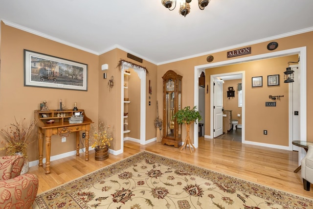 entryway featuring wood finished floors, ornamental molding, and baseboards
