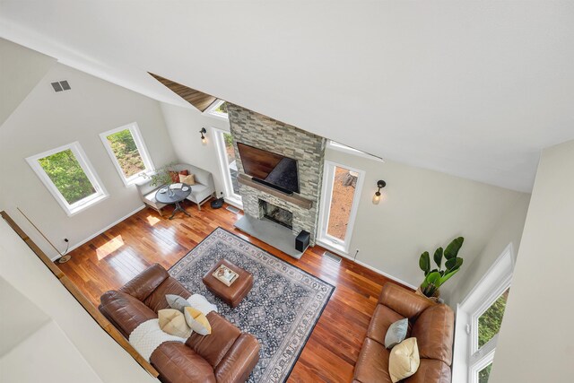 204 Chase Way, Manchester, NH 03104 - living area with wood finished floors, a stone fireplace, baseboards, and high vaulted ceiling
