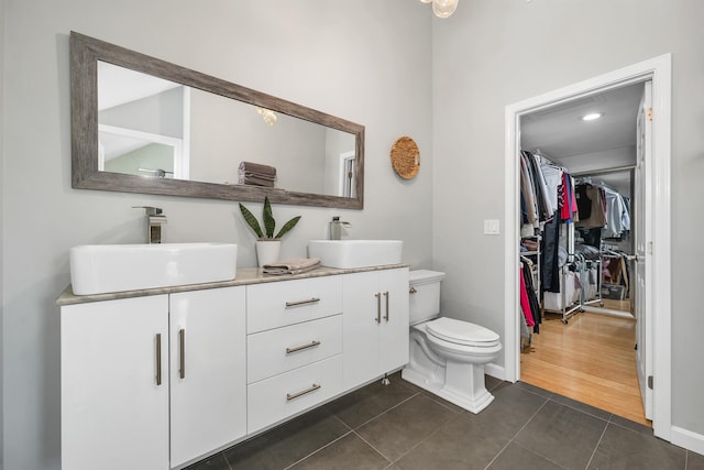 204 Chase Way, Manchester, NH 03104 - full bath featuring tile patterned floors, double vanity, toilet, a spacious closet, and baseboards