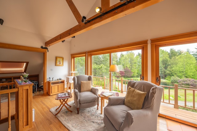 living room with high vaulted ceiling, beamed ceiling, and light wood finished floors