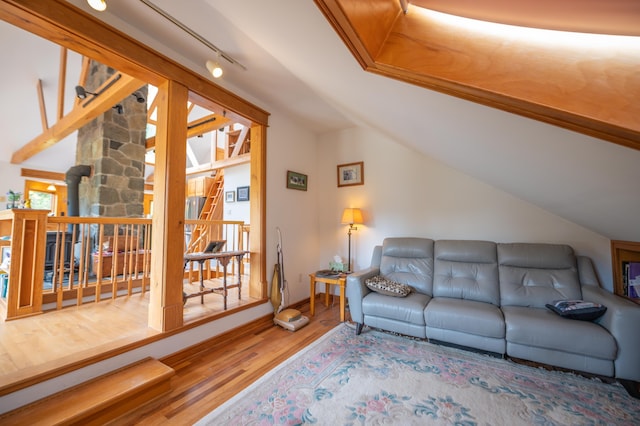 living area featuring wood finished floors, vaulted ceiling, and baseboards