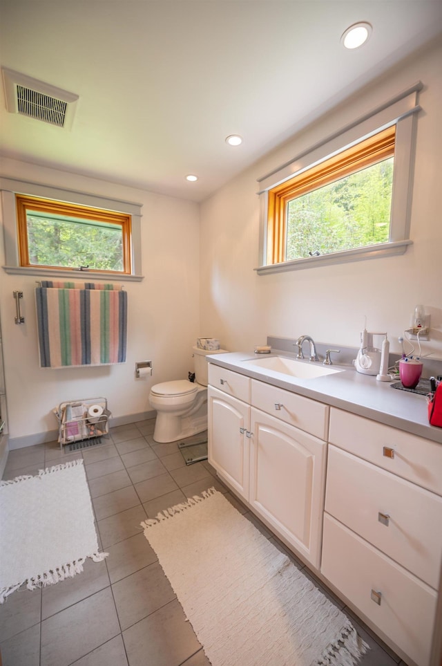 bathroom featuring toilet, plenty of natural light, vanity, tile patterned floors, and recessed lighting