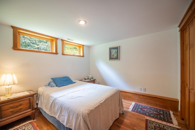 bedroom featuring wood finished floors, recessed lighting, and a closet