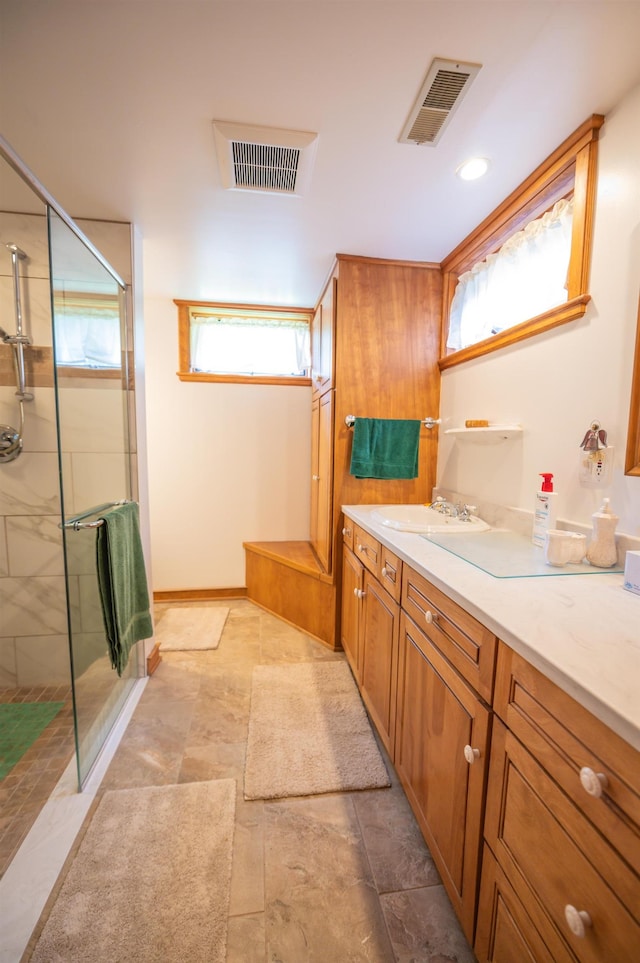 full bathroom with a shower with shower door and vanity