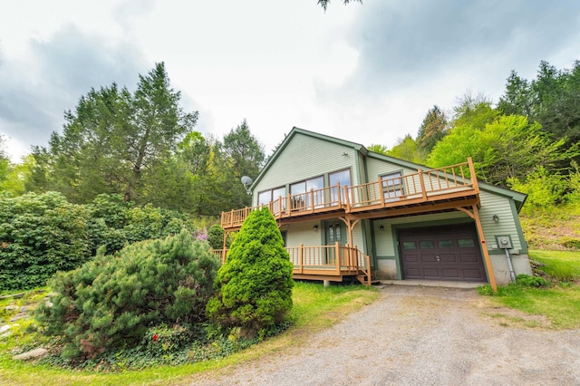 view of front facade with driveway, a deck, and an attached garage
