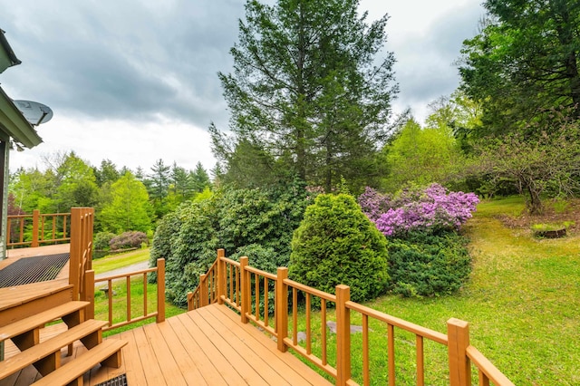 wooden terrace featuring a yard and view of wooded area