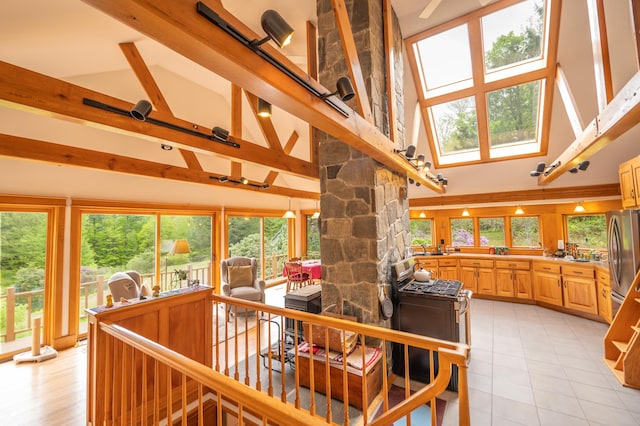 staircase featuring high vaulted ceiling, a skylight, and tile patterned flooring
