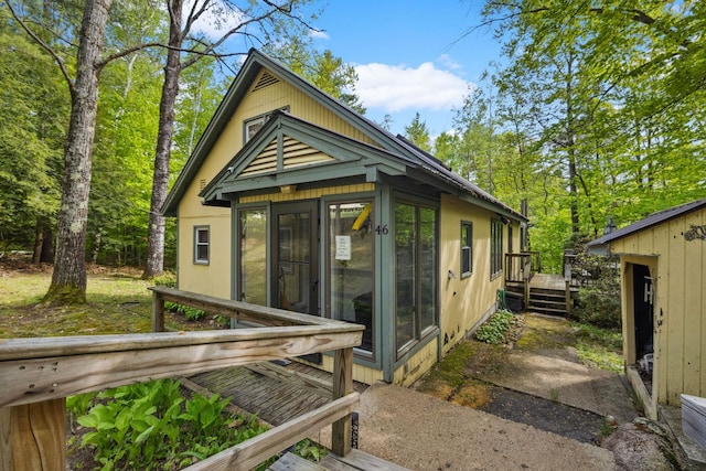 46 Crestwood Dr, Conway, NH 03860 - back of property featuring a deck, an outdoor structure, a sunroom, and stucco siding