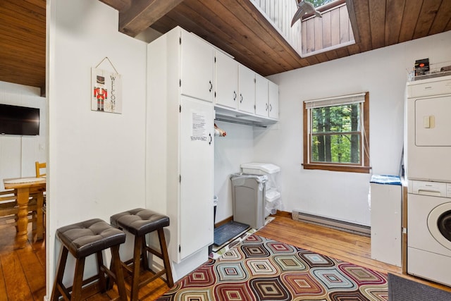 46 Crestwood Dr, Conway, NH 03860 - laundry area featuring stacked washer / dryer, baseboard heating, hardwood / wood-style flooring, wooden ceiling, and baseboards