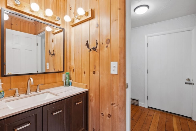 46 Crestwood Dr, Conway, NH 03860 - bathroom with hardwood / wood-style flooring, wood walls, ornamental molding, and vanity