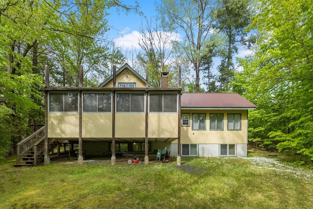46 Crestwood Dr, Conway, NH 03860 - back of property featuring a sunroom, a chimney, stairway, and a lawn