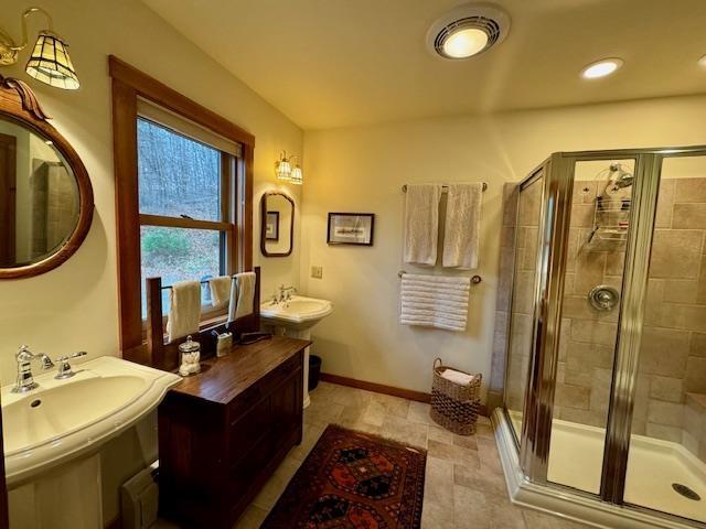 133 Ben Dexter Rd, Topsham, VT 05076 - bathroom featuring a stall shower, baseboards, a sink, and stone finish floors