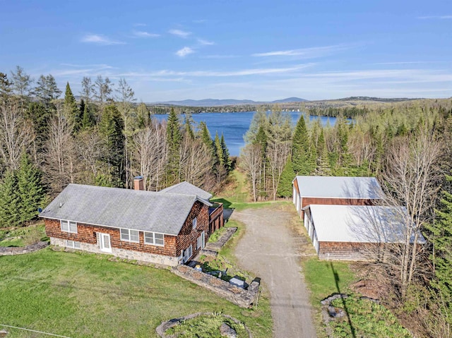 aerial view of property and surrounding area with a water and mountain view and a forest
