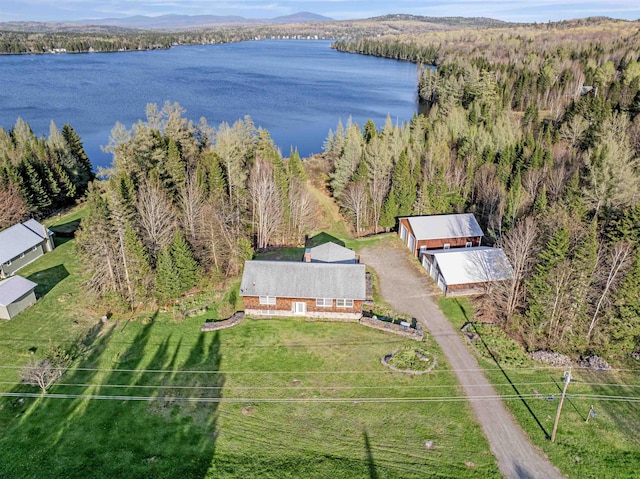 view of property location featuring a nearby body of water and a heavily wooded area