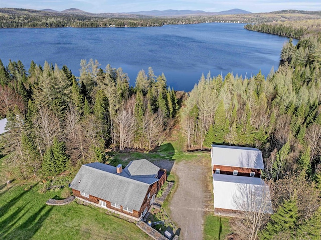 view of subject property featuring a water and mountain view and a heavily wooded area