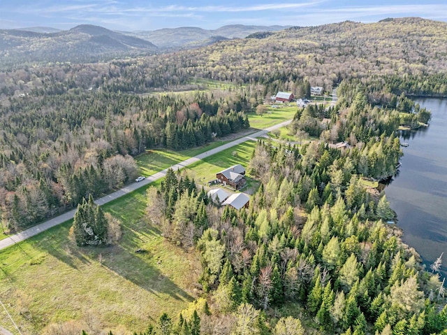 view of property location featuring a water and mountain view and a forest