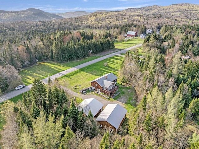 aerial view of property's location featuring a heavily wooded area and mountains