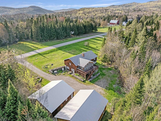view from above of property featuring a heavily wooded area and a mountainous background