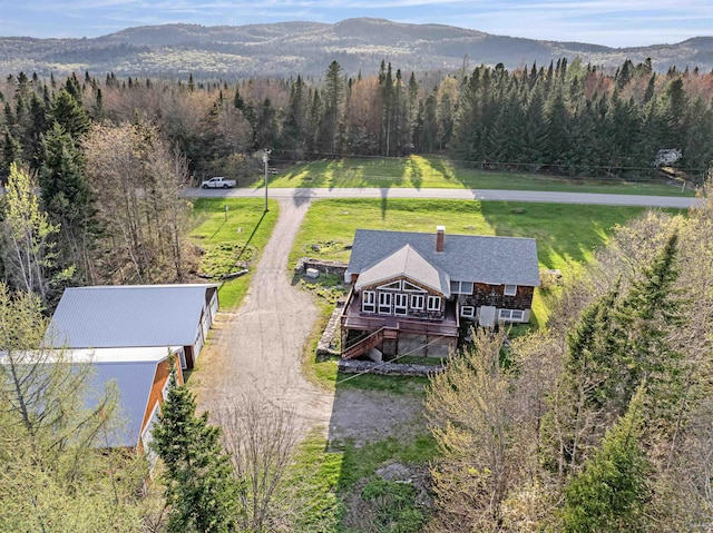 view of subject property featuring a heavily wooded area and a mountain backdrop