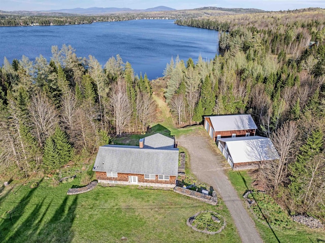 aerial view of property and surrounding area with a large body of water and a heavily wooded area