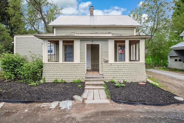 16 Shurtleff Pl, Barre City, VT 05641 - view of front of home with covered porch, metal roof, and a chimney