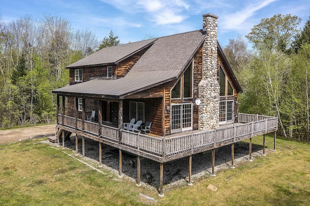 back of property with a yard, a chimney, and a wooden deck