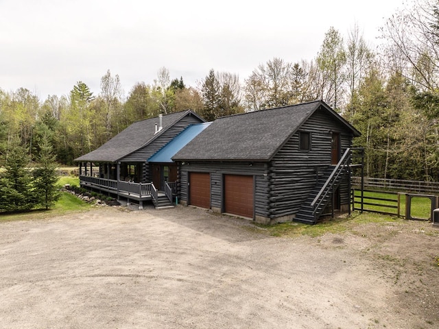 42 Chickadee Ln, Littleton, NH 03561 - view of front of home featuring fence, log exterior, an attached garage, roof with shingles, and driveway
