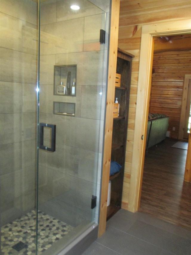 42 Chickadee Ln, Littleton, NH 03561 - bathroom with tile patterned flooring, a shower stall, and wood walls