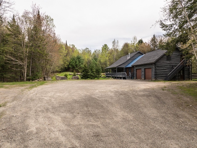 42 Chickadee Ln, Littleton, NH 03561 - view of yard with an attached garage, dirt driveway, and stairs