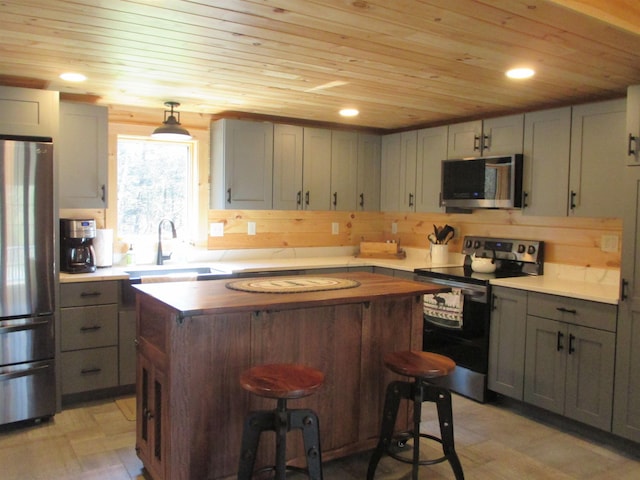 42 Chickadee Ln, Littleton, NH 03561 - kitchen featuring stainless steel appliances, wooden ceiling, gray cabinetry, wooden counters, and a center island