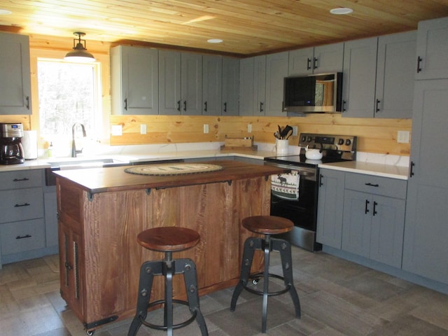 42 Chickadee Ln, Littleton, NH 03561 - kitchen featuring stainless steel appliances, wooden ceiling, a sink, a center island, and light countertops