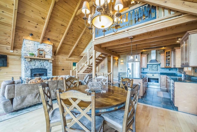 42 Peak Vista Ln, Madison, NH 03849 - dining area featuring light wood-style floors, a fireplace, a chandelier, wood ceiling with exposed beams, and stairway