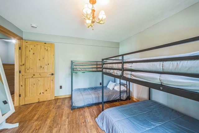 42 Peak Vista Ln, Madison, NH 03849 - bedroom with wood finished floors, a chandelier, and baseboards