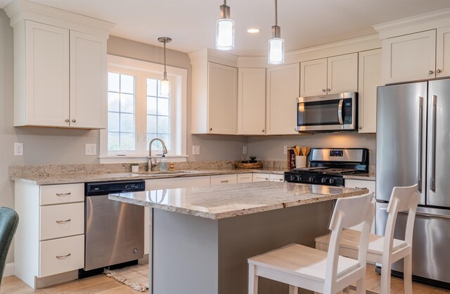 21 Lovering Rd, North Hampton, NH 03862 - kitchen with stainless steel appliances, a sink, a kitchen island, light stone counters, and a breakfast bar