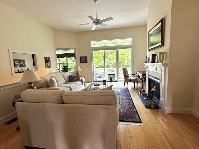 7 Ebenezers Way, Hollis, NH 03049 - living area featuring light wood-style flooring, baseboards, a ceiling fan, and a fireplace with flush hearth