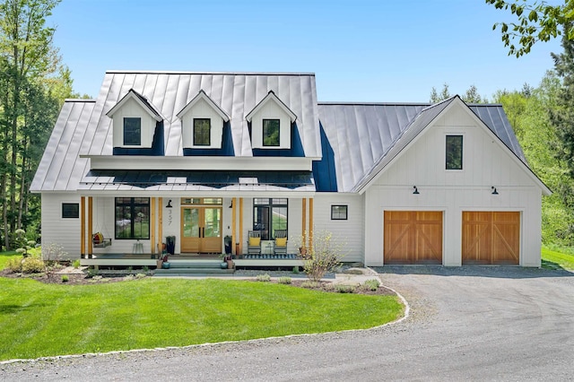 modern farmhouse featuring covered porch, a standing seam roof, a front lawn, and french doors