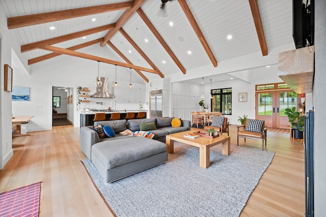 living area featuring light wood-style floors, high vaulted ceiling, beam ceiling, recessed lighting, and baseboards