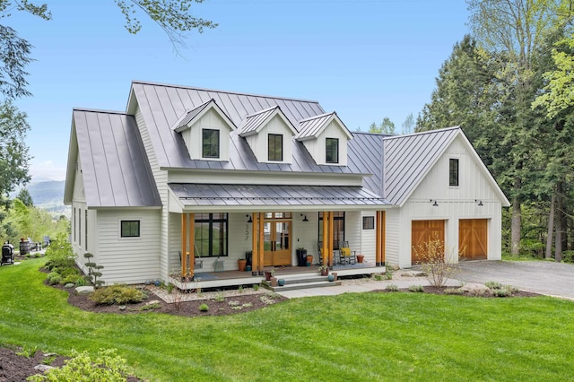 modern farmhouse style home with a standing seam roof, a porch, and a front lawn
