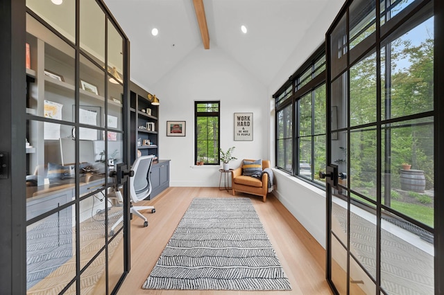 office area featuring beam ceiling, healthy amount of natural light, wood finished floors, baseboards, and high vaulted ceiling