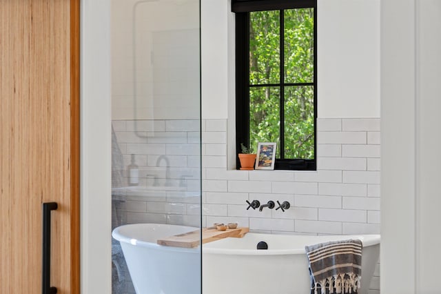 full bath featuring tile walls and a soaking tub