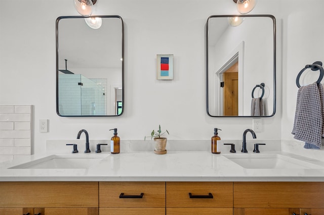 bathroom with a shower stall and double vanity