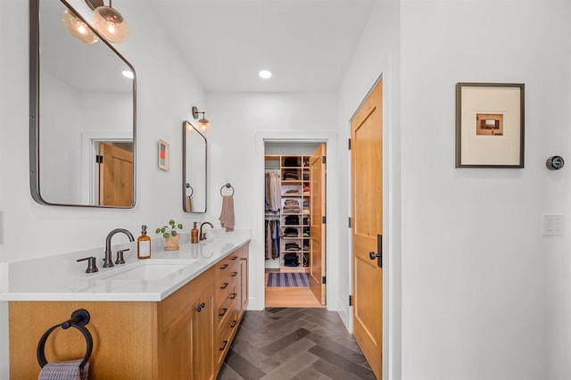 bathroom featuring double vanity, a spacious closet, and recessed lighting