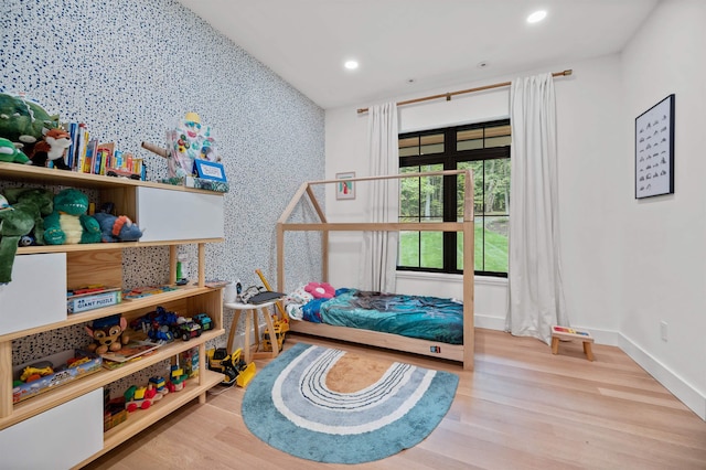 bedroom with recessed lighting, wood finished floors, and baseboards