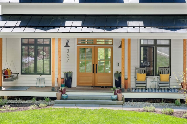 property entrance featuring covered porch, a standing seam roof, and metal roof