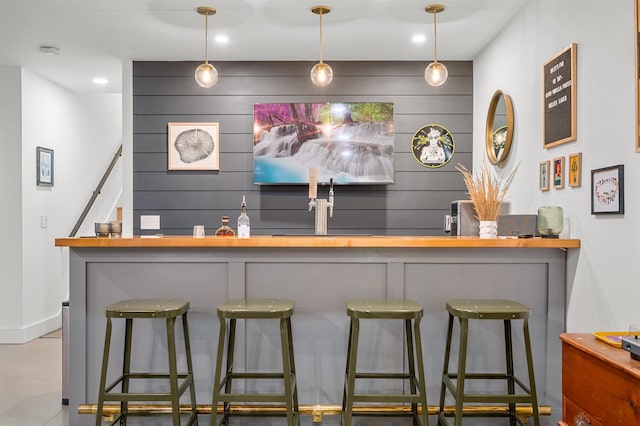 indoor wet bar featuring baseboards, pendant lighting, recessed lighting, and stairway