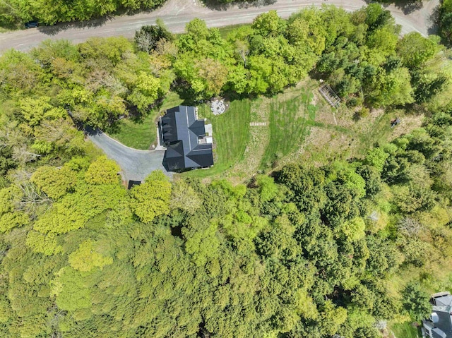 aerial view of property and surrounding area with a heavily wooded area