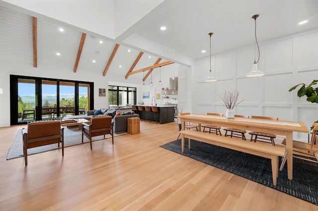 dining area with a decorative wall, beamed ceiling, light wood-style floors, high vaulted ceiling, and recessed lighting