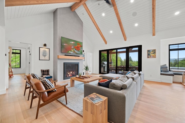 living room featuring high vaulted ceiling, light wood finished floors, a large fireplace, beam ceiling, and recessed lighting