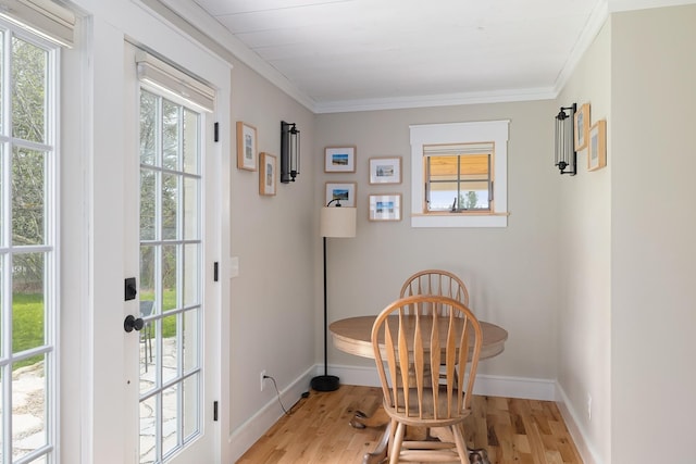 doorway to outside featuring light wood-type flooring, baseboards, and crown molding
