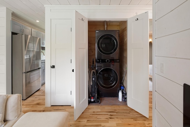 washroom featuring estacked washer and dryer, light wood-type flooring, and recessed lighting
